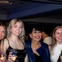 Five grads smile with Philly holding champagne flutes